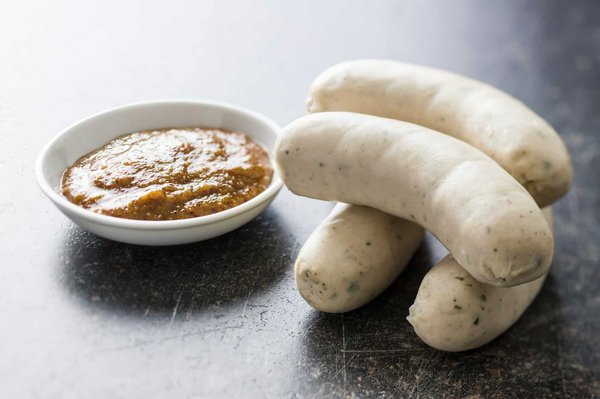 Wie bereitet man eine klassische Weißwurst mit süßem Senf und frischen Brezeln zu?
