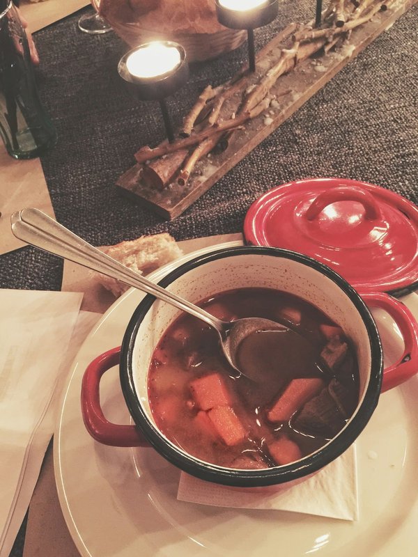 Wie bereitet man einen deftigen Biergulasch mit dunklem Bier und Kartoffelklößen zu?